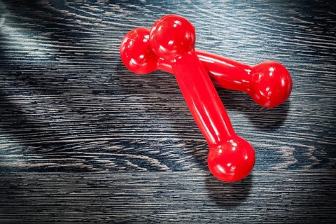 Red dumbbell weights on vintage wooden board