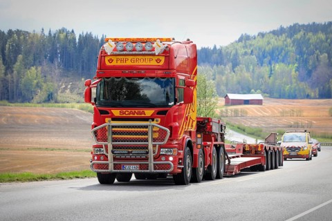Scania truck of PHP Group in front of gooseneck trailer returns from delivering oversize load,