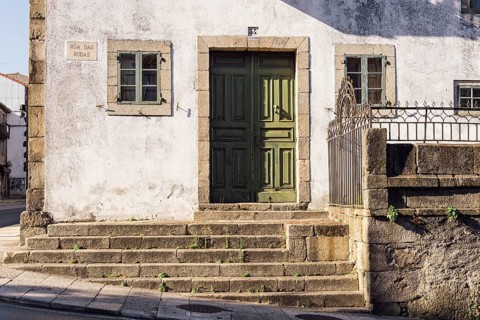 Santiago de Compostela, Spain, July 18, 2020: Old house with green wooden door in medieval town