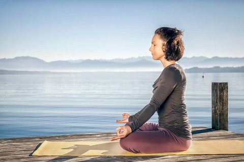 A pretty woman doing yoga at the lake