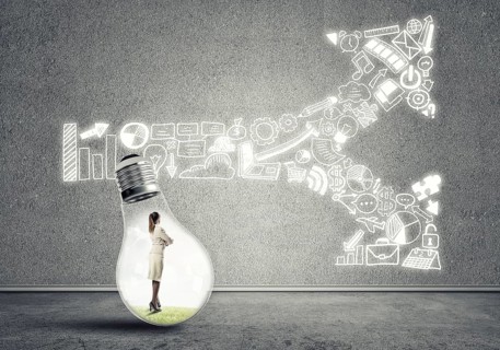 Businesswoman inside of light bulb in empty concrete room