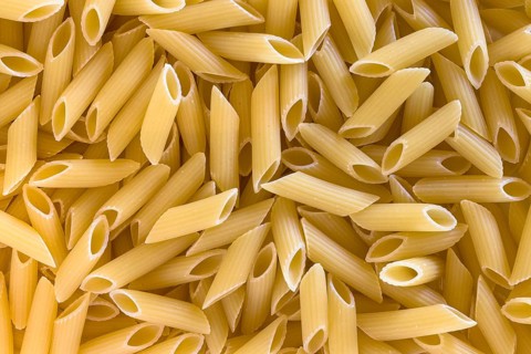 Extreme close up of uncooked italian penne pasta background