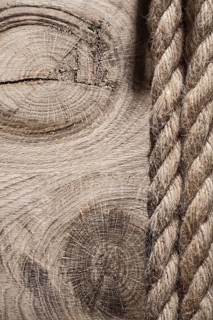 Vintage spirally twisted flax ropes on wooden board top view