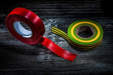 Rolled insulation tapes on vintage wooden board