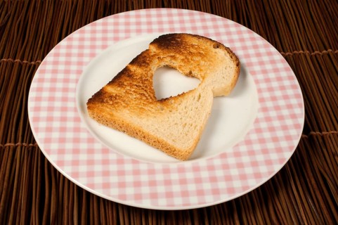 Toast with heart-shaped set in white plate