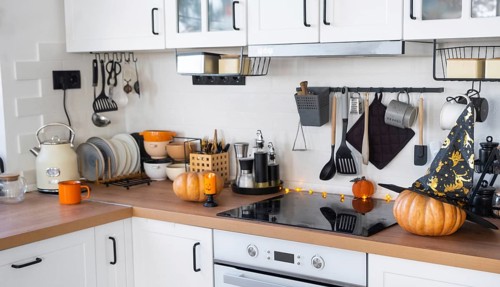 Decor of the white classic kitchen with pumpkins for Halloween and harvest. Autumn mood in the home