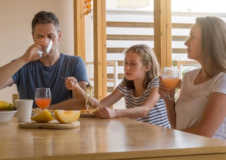 Dad, mom and their daughter have lunch outdoors