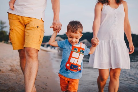 Family holiday in summer. Young Caucasian family foot walking barefoot sandy beach, shore river