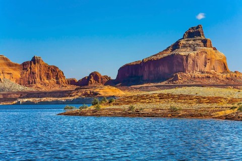 Huge picturesque lake with blue water, among outcrops of red sandstone. Lake Powell is a reservoir