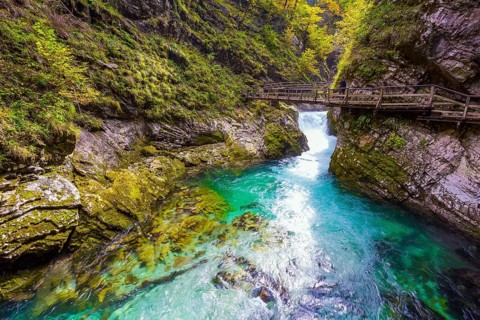 Slovenia. Bubbling waterfalls on a mountain river. On the slopes of the gorge laid wooden walkways