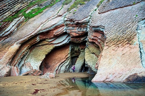 Huge cave on the beach. Low tide in the Atlantic. Flysch - unique landscape of underwater rocks