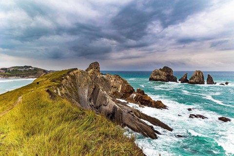 Rocky coastline of the Atlantic Ocean. Spanish coast, Cantabria. Portio beach. Stormy autumn day in