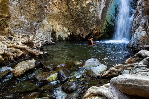 Unrecognised woman swimming in the natural pool of Millomeri waterfalls Platres, Troodos, Cyprus