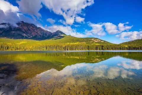 Frosty morning in the Rocky Mountains, Canada. Clear water Pyramid Lake reflects the clouds and