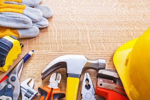 Organized copyspace set tools helmet wrench nippers pliers hammer cutter tapeline gloves on wooden