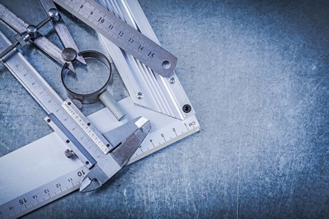 Metal ruler try square trammel caliper construction pair of compasses on metallic background