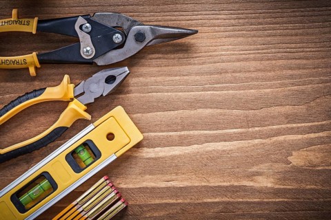Pliers tin snips construction level wooden meter on wood board