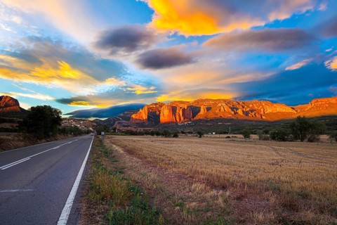 Red sunset. The magnificent Mallets of Riglos cliffs. Scenic paved highway. Romantic trip to Spain.