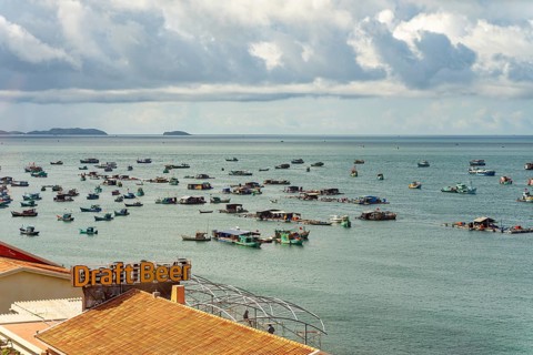 Calm sea with scattered boats and a cloudy sky in a coastal setting, palms, city, sun city, Phu