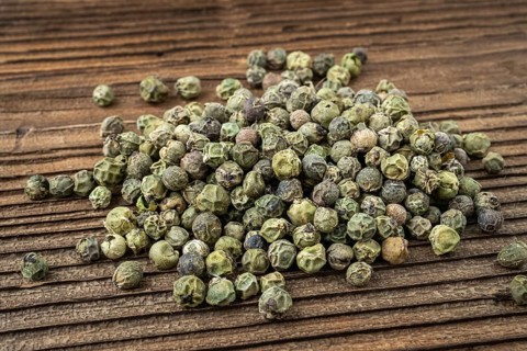Dried spices green pepper. Peppercorn on dark rustic wooden background