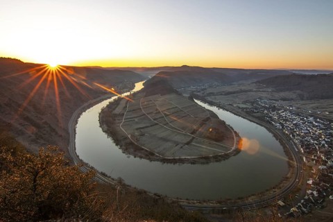 Sunrise over the Moselle. The river meanders in a narrow loop through a valley surrounded by