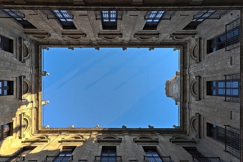 A courtyard in the Royal Tobacco Factory of Seville photographed from below. The bird protection