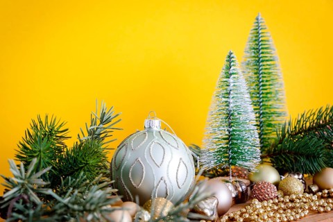 A Christmas decoration glass balls with fir trees on yellow background