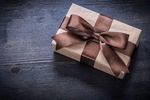 Gift box-container with bow on vintage wooden board