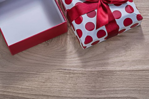 Red opened gift box on wooden board horizontal version celebrations concept