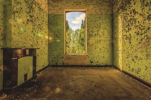 Abandoned room with shimmering green walls and a window overlooking trees, Prison H11, Lost Place,