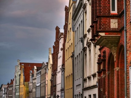 A row of historic red brick buildings under a cloudy sky, gothmund, travemünde, lübeck, germany