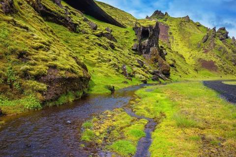Picturesque basalt hills covered with green grass and moss-polar. At the bottom of the canyon