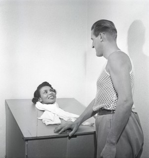 Beauty care in the 1950s. A young woman is sitting in a steam sauna, with only her head sticking up