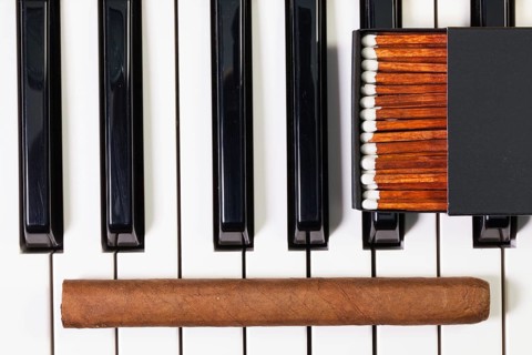 Detail of piano keyboard and luxury cigar