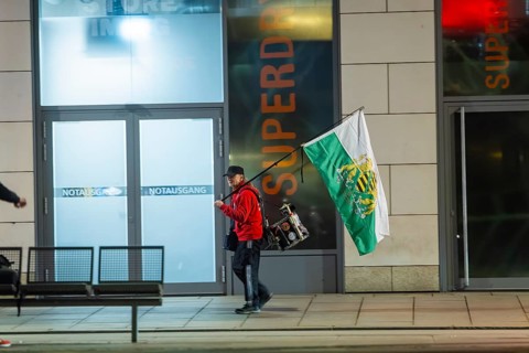 A supporter of the radical Free Saxons, walks with a Saxon flag and drum on Wilsdruffer Straße for