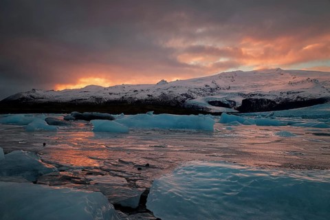 Ice floes on the black sea sand and the coast Fjallsarlon lagoon