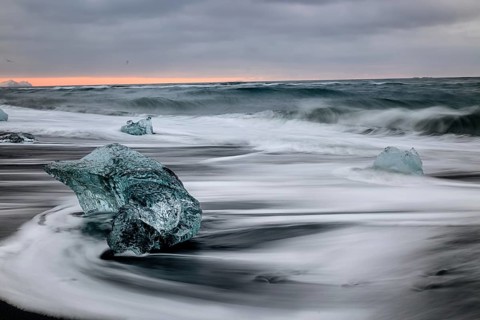 Ice floes on the black sea sand and the coast Jokulsarlon