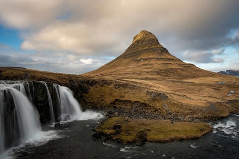 The Kirkjufell mountain and the kirkjufellfoss waterfall at grundarfjordur at Snaefellsnes
