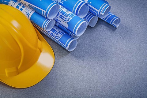 Hard hat blue construction drawings on grey background