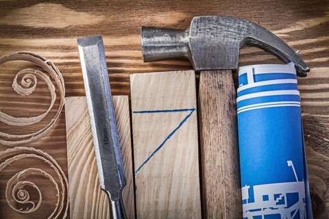 Blue rolled construction drawing claw hammer firmer chisel wooden studs curled shavings on vintage