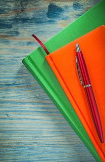 Notepads pen on wooden board office concept