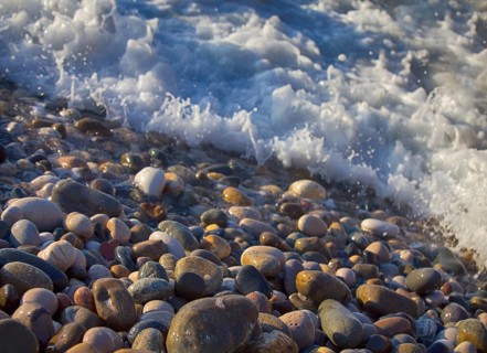 Beach of multi-colored round pebbles, and the splash of salty waves. Black sea, Caucasus