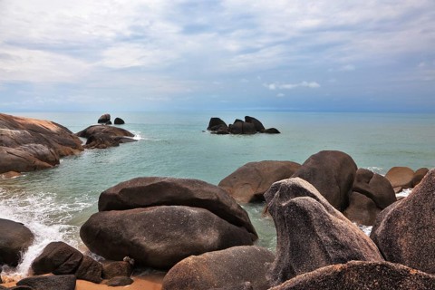 Picturesque coastal cliffs and subdued after a storm sea. Koh Samui