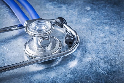 Stethoscope on scratched metallic background top view medicine concept