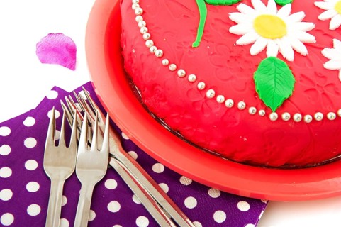 Birthday cake in pink with napkins and forks