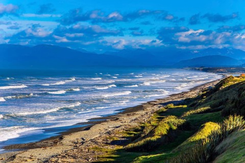 Powerful ocean surf on South island. Sunset. Rocky and stone shores of the ocean. The southernmost