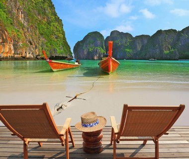 Two convenient comfortable guest sun loungers and a bedside table are worth on a wooden platform.