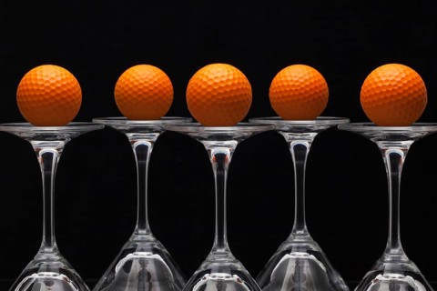 Five glasses of champagne with golf balls
