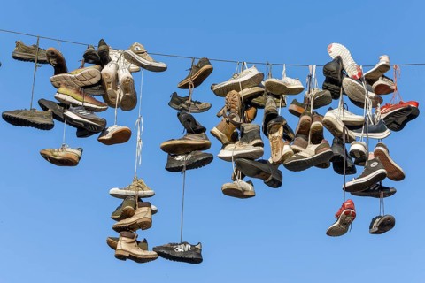 Shoes, boots, trainers, ... hanging on a rope in the air above the Grapengießerstraße medieval old