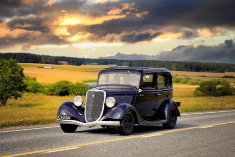 Black Ford Fordor Dillinger Special year 1934 on road on Maisemaruise 2019 car cruise. Edited sky.